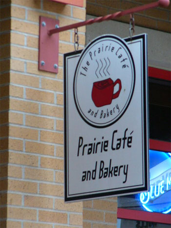 The hanging Prairie Café and Bakery sign with the red coffee cup